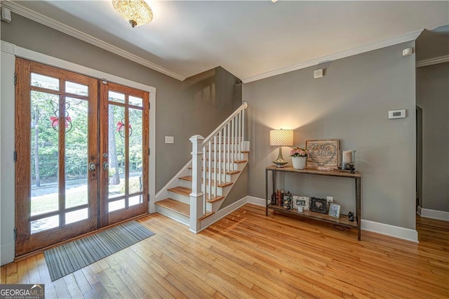 doorway featuring french doors, ornamental molding, hardwood / wood-style flooring, stairs, and baseboards