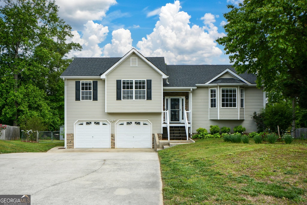 view of front of house with a garage, fence, a front yard, and concrete driveway