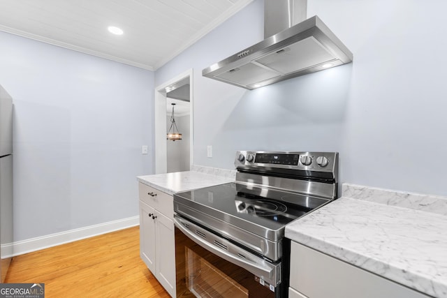 kitchen featuring crown molding, electric range, wall chimney exhaust hood, white cabinetry, and light wood-type flooring