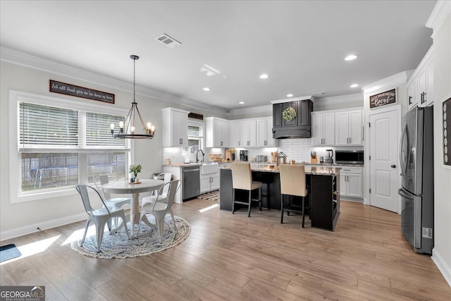 4575 Birch Way, Loganville, GA 30052 - dining space featuring crown molding, baseboards, a chandelier, light wood-type flooring, and recessed lighting