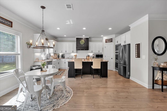 4575 Birch Way, Loganville, GA 30052 - dining space with crown molding, baseboards, a chandelier, light wood-style floors, and recessed lighting