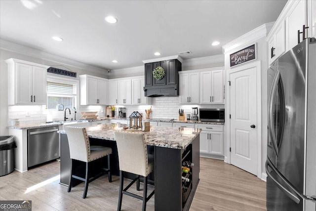 4575 Birch Way, Loganville, GA 30052 - kitchen with appliances with stainless steel finishes, a kitchen island, ornamental molding, tasteful backsplash, and white cabinetry