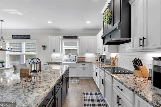 4575 Birch Way, Loganville, GA 30052 - kitchen featuring a sink, black electric cooktop, white cabinets, healthy amount of natural light, and crown molding