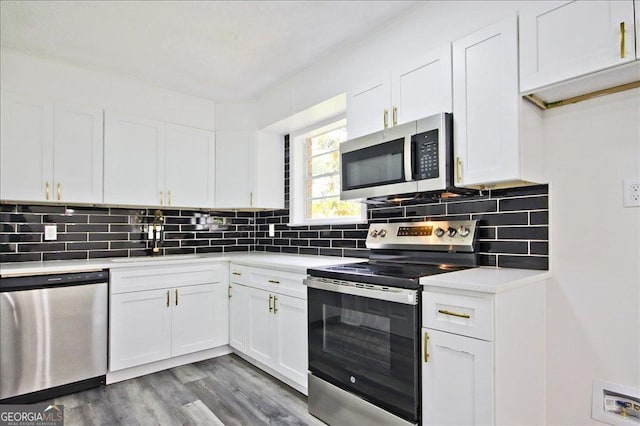 4701 Flat Shoals Rd Unit 35E, Union City, GA 30291 - kitchen featuring appliances with stainless steel finishes, white cabinets, light countertops, decorative backsplash, and wood finished floors