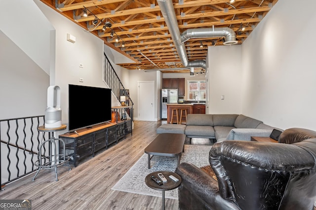 living area featuring light wood-style floors and stairs