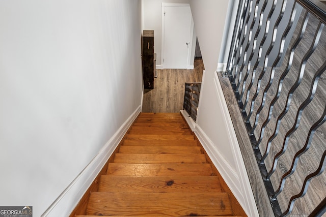 staircase with wood finished floors and baseboards