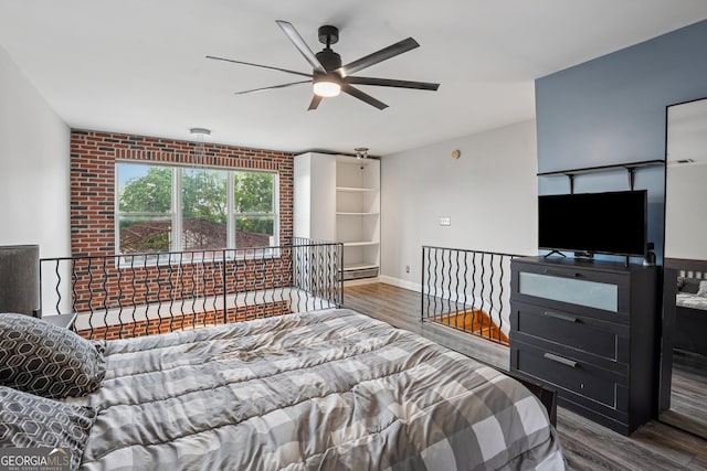 bedroom with wood finished floors, baseboards, and a baseboard heating unit