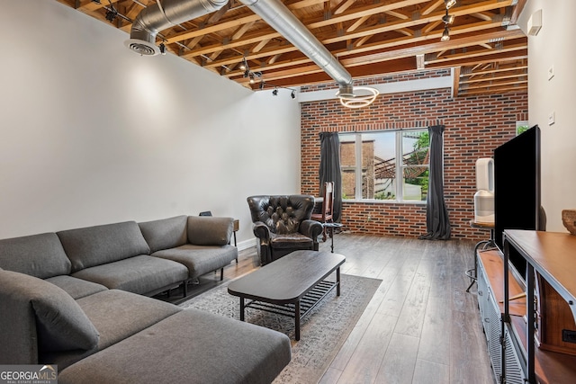 living room with brick wall and hardwood / wood-style flooring