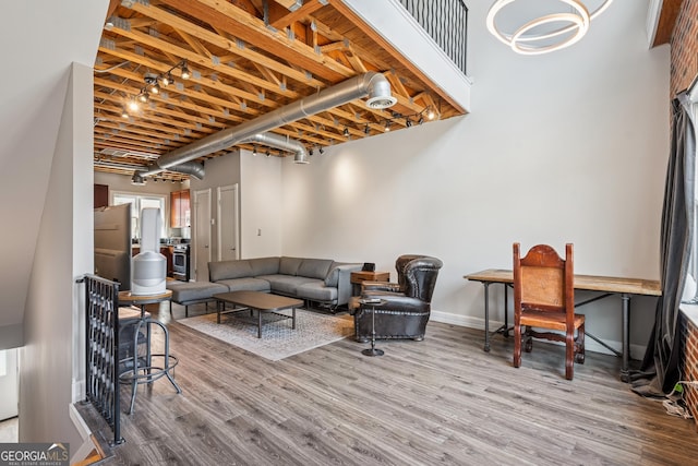 living room featuring wood finished floors, baseboards, and a chandelier