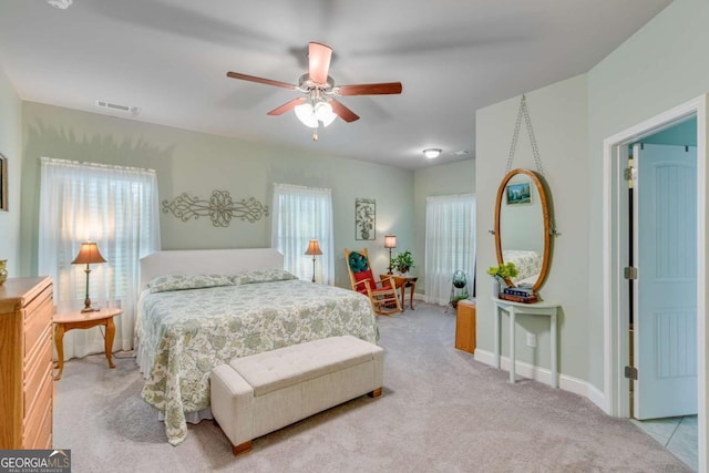 bedroom featuring light carpet, baseboards, a ceiling fan, and visible vents