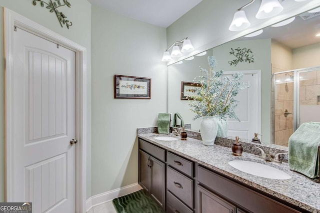 full bathroom featuring baseboards, visible vents, a sink, a shower stall, and double vanity