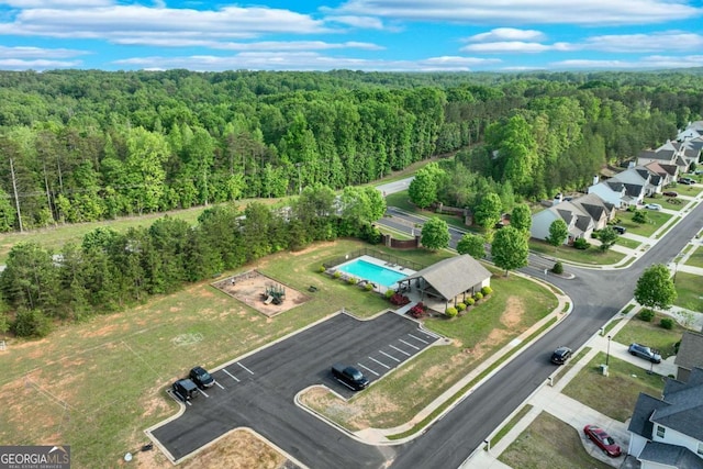 drone / aerial view featuring a wooded view