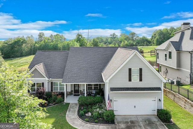 view of front of house featuring fence, an attached garage, concrete driveway, and a front yard