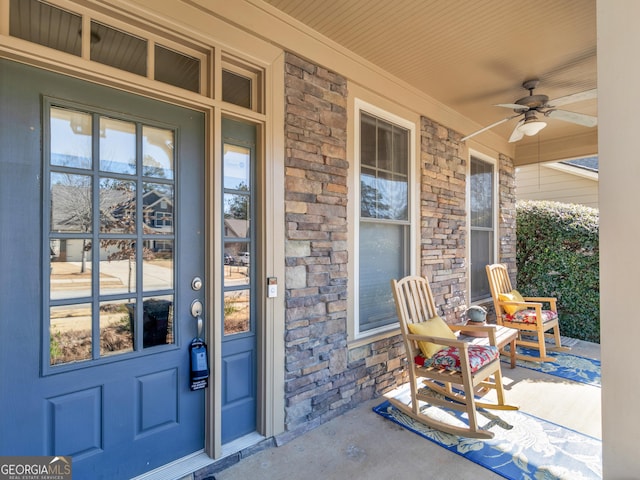 property entrance with stone siding, a porch, and ceiling fan