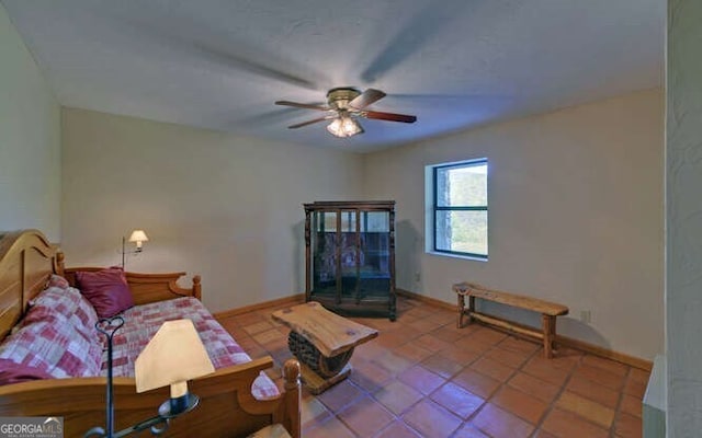 living area with tile patterned flooring, baseboards, and ceiling fan