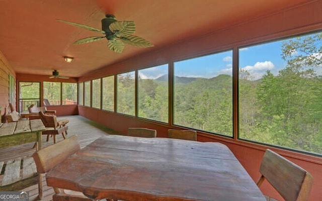 sunroom / solarium with a wooded view