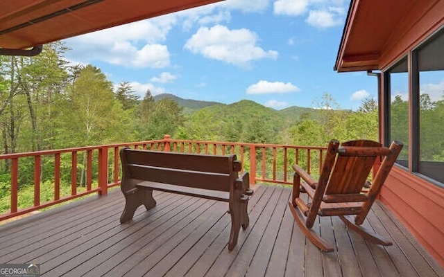 wooden deck featuring a mountain view and a wooded view