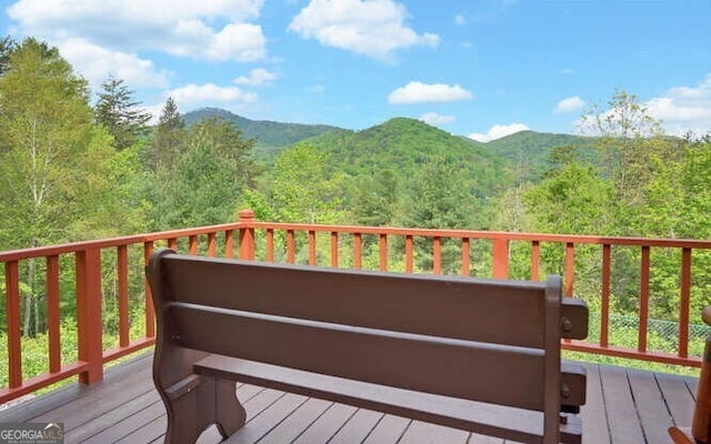 deck with a forest view and a mountain view
