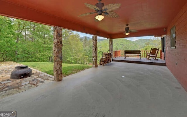 view of patio / terrace featuring a view of trees and ceiling fan