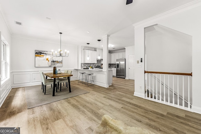 3460 Lockmed Dr, Peachtree Corners, GA 30092 - dining space with a chandelier, light wood-style flooring, and ornamental molding