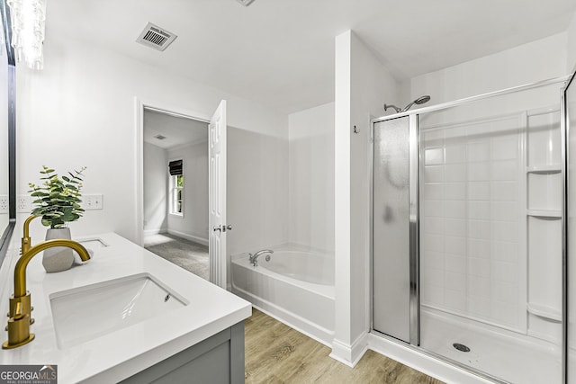 3460 Lockmed Dr, Peachtree Corners, GA 30092 - bathroom featuring a shower stall, double vanity, a garden tub, and wood finished floors