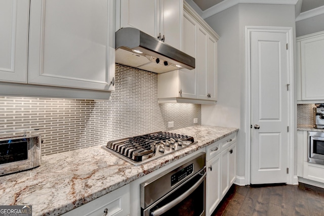 919 Olmsted Ln, Johns Creek, GA 30097 - kitchen with white cabinetry, dark wood-type flooring, under cabinet range hood, appliances with stainless steel finishes, and decorative backsplash