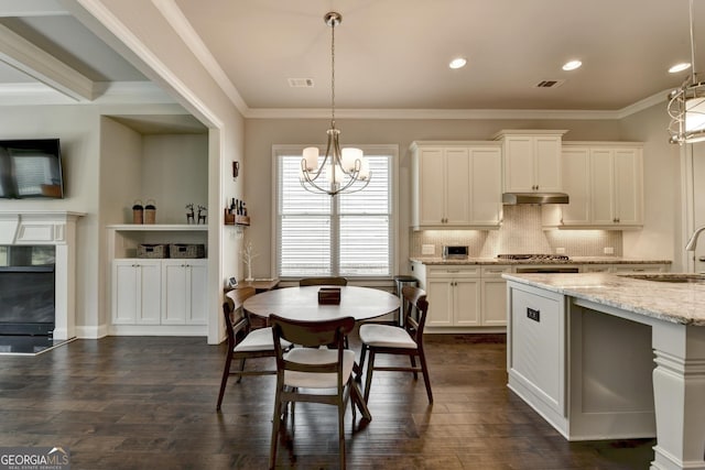 919 Olmsted Ln, Johns Creek, GA 30097 - kitchen with a sink, a chandelier, light stone countertops, decorative backsplash, and dark wood-style floors