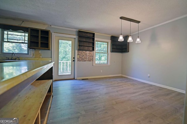 interior space featuring a textured ceiling, open shelves, and wood finished floors