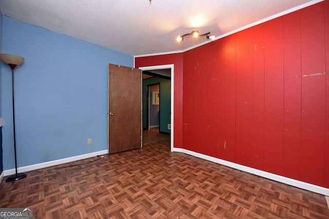 unfurnished room with baseboards and a textured ceiling
