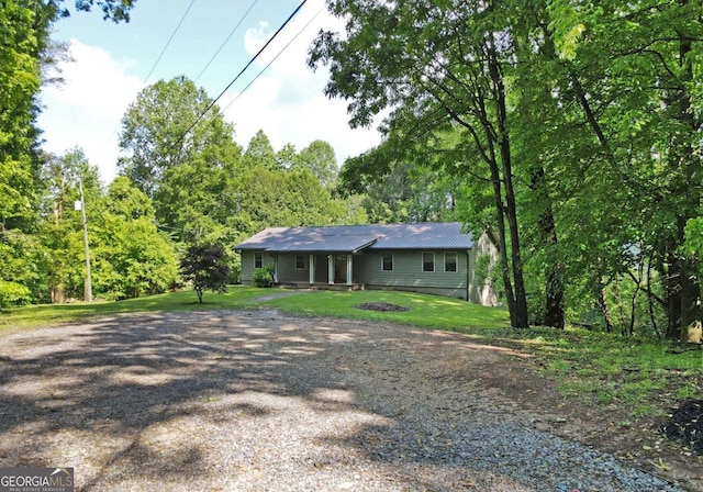 ranch-style house with a front lawn and gravel driveway