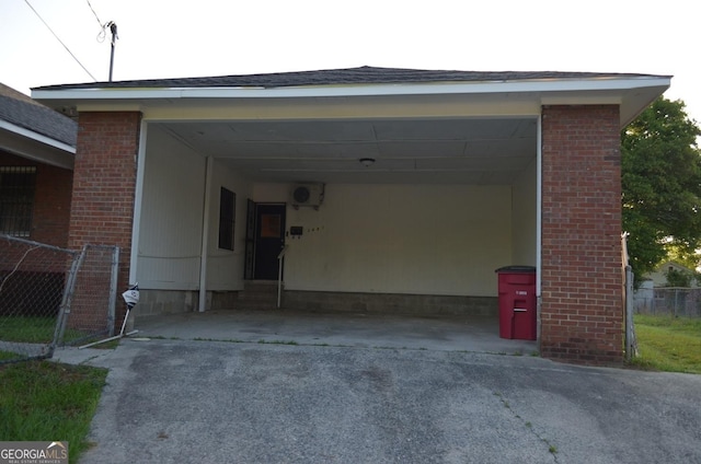 garage featuring aphalt driveway, fence, and an attached carport
