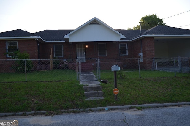 view of front of home featuring a fenced front yard, a front lawn, covered porch, and brick siding
