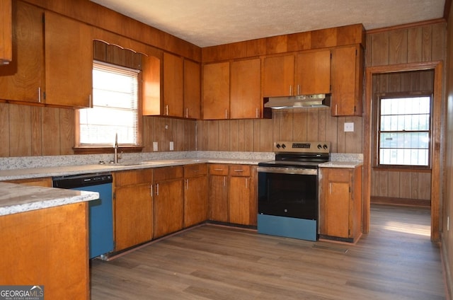kitchen featuring a sink, brown cabinetry, stainless steel electric range, dishwasher, and under cabinet range hood