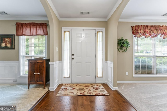 entrance foyer with dark wood finished floors, visible vents, and arched walkways