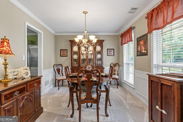 dining room with ornamental molding, a decorative wall, a chandelier, and visible vents