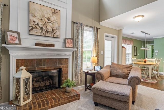 sitting room featuring baseboards, a brick fireplace, visible vents, and crown molding
