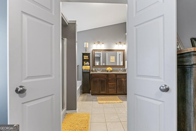bathroom with walk in shower, tile patterned floors, double vanity, and a sink