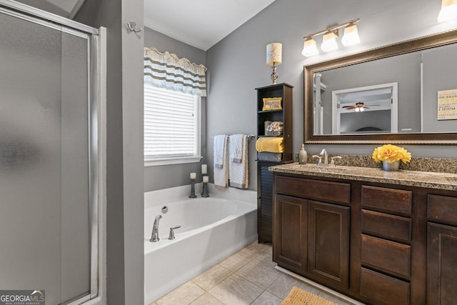 full bathroom featuring a stall shower, a sink, tile patterned floors, a garden tub, and double vanity