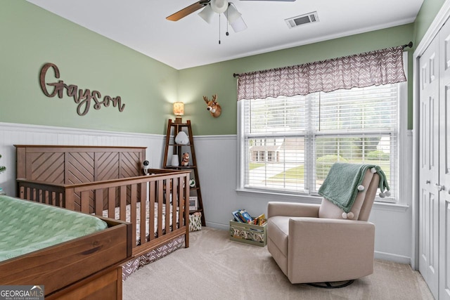 bedroom featuring a closet, wainscoting, visible vents, and carpet