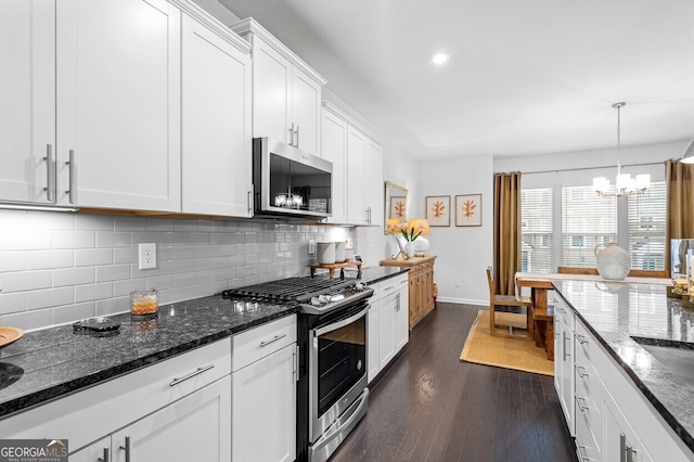 1098 Caruso Dr, Buford, GA 30518 - kitchen featuring stainless steel appliances, a chandelier, white cabinetry, dark wood-style flooring, and decorative backsplash