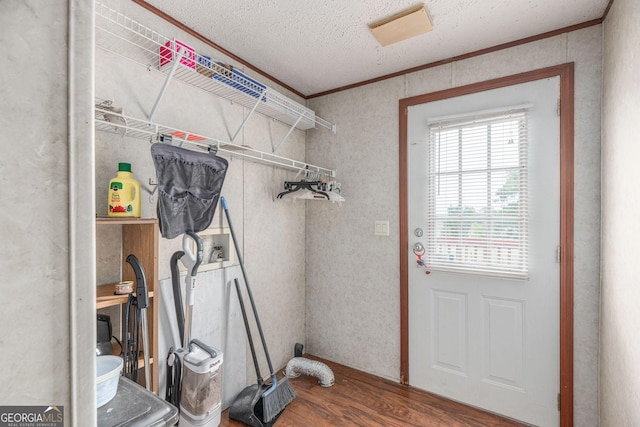laundry area featuring laundry area, crown molding, a textured ceiling, and wood finished floors