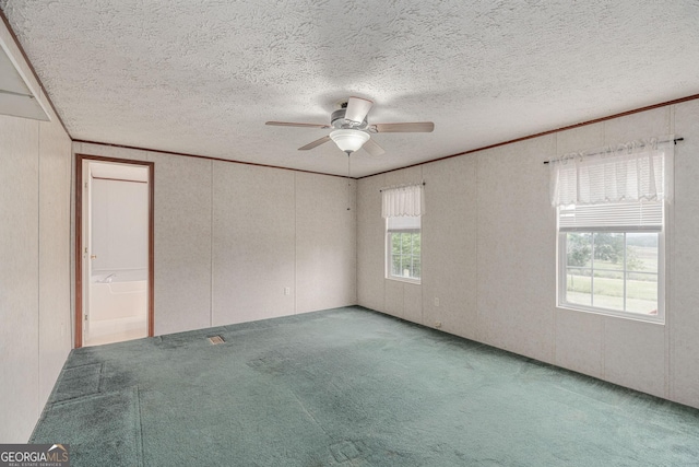 carpeted spare room with a textured ceiling, a decorative wall, and a ceiling fan