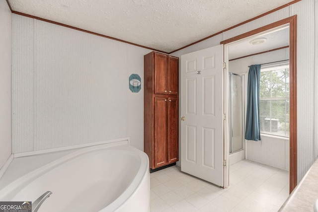 bathroom with a bath, an enclosed shower, ornamental molding, and a textured ceiling