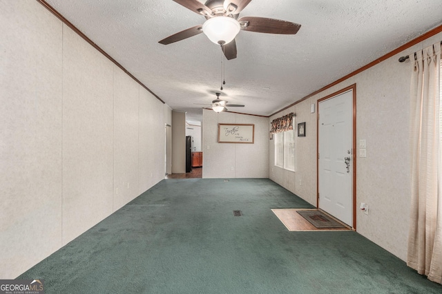spare room with carpet floors, ceiling fan, crown molding, and a textured ceiling