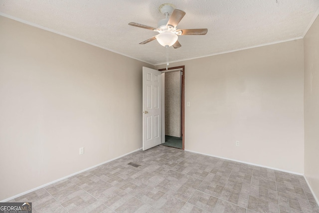 empty room featuring a textured ceiling, baseboards, a ceiling fan, and ornamental molding