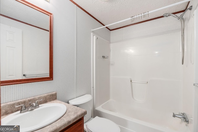 full bath with a textured ceiling, toilet, ornamental molding, vanity, and shower / washtub combination