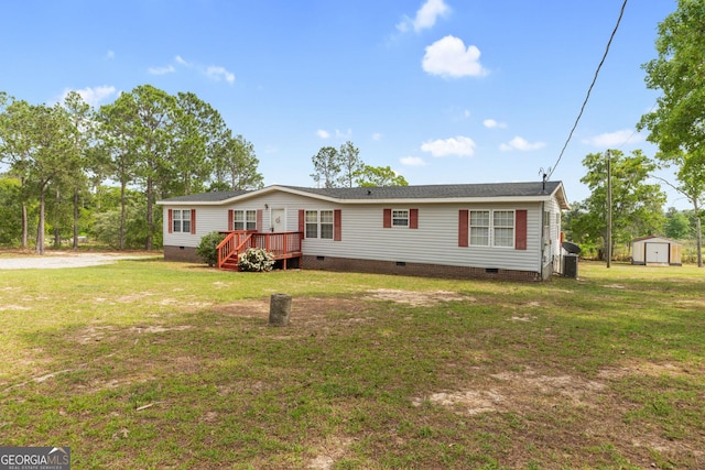 manufactured / mobile home with a deck, a storage shed, an outdoor structure, crawl space, and a front lawn