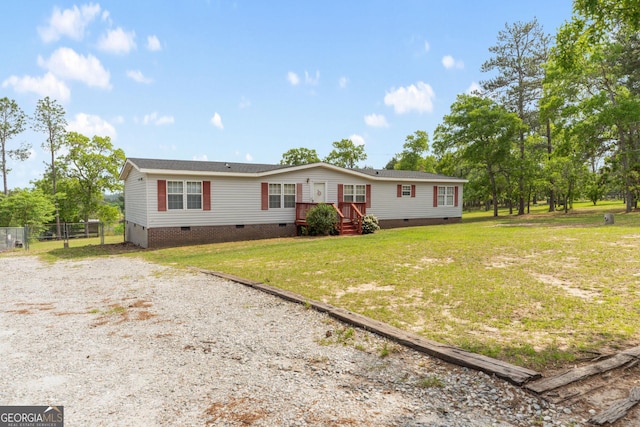 manufactured / mobile home featuring a front lawn, crawl space, fence, and gravel driveway