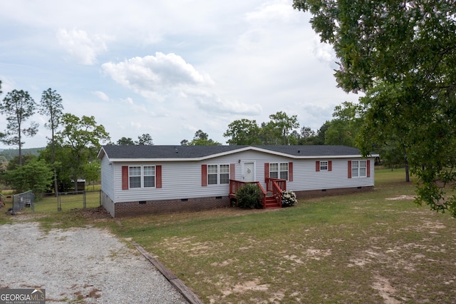 manufactured / mobile home featuring a front yard, roof with shingles, fence, and crawl space