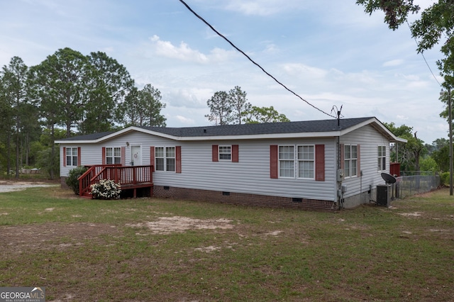 manufactured / mobile home featuring a wooden deck, crawl space, fence, and a front yard